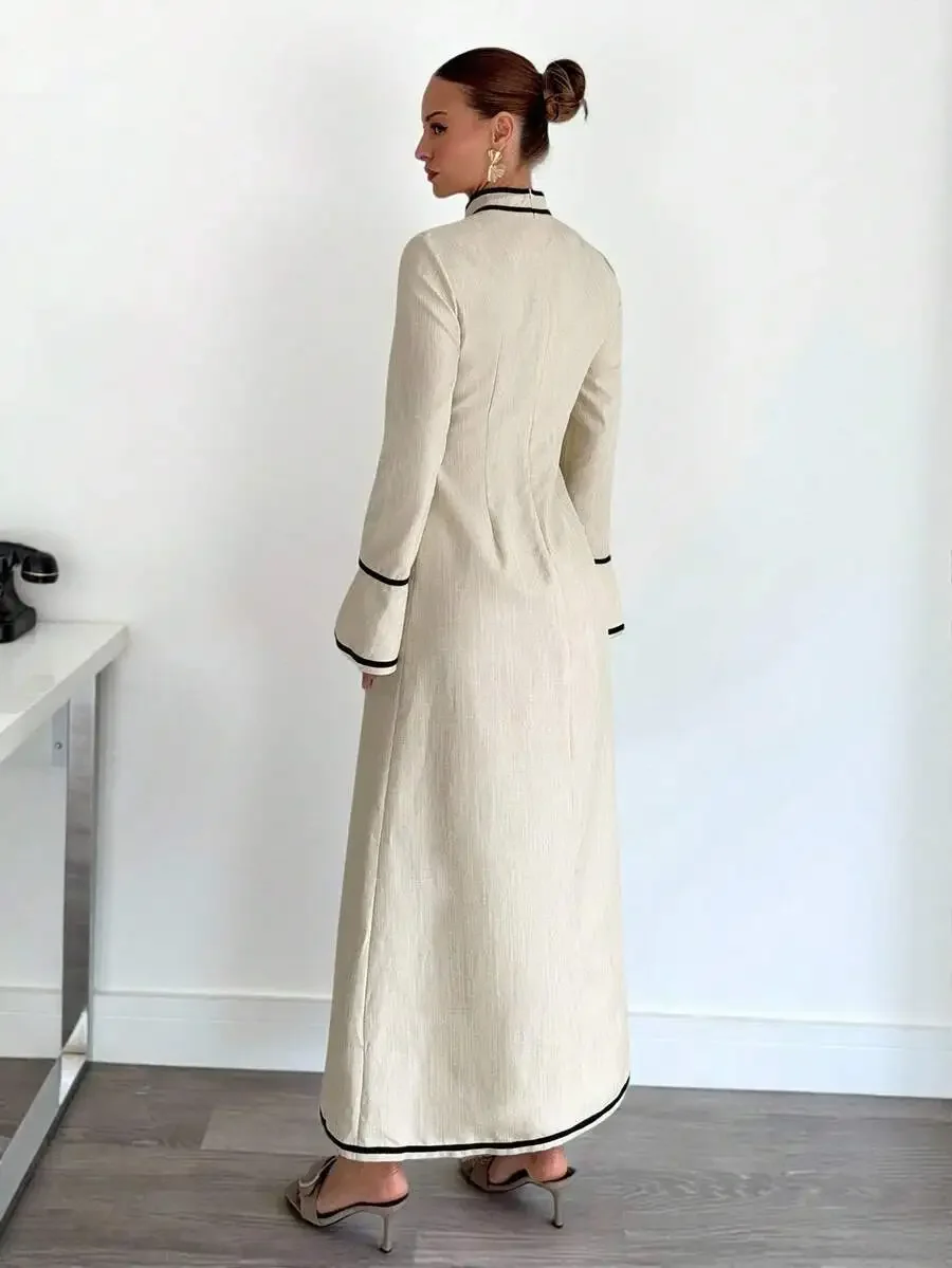 Cream High-Neck Long Sleeve Maxi Dress With Black Piping On Collar, Cuffs, Hem And Side Slit—Elegant Office To Evening Wear
Cream High-Neck Long Sleeve Maxi Dress With Black Piping On Collar, Cuffs, Hem And Side Slit—Elegant Office To Evening Wear
