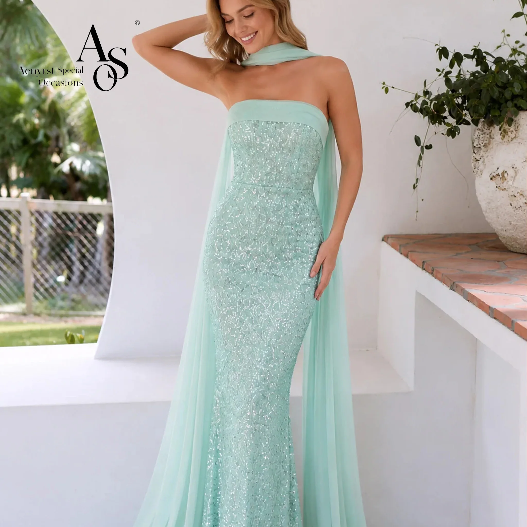 Green strapless sleeveless floor-length mermaid formal gown featuring sequins a halter neck and ribbon detailing
Green strapless sleeveless floor-length mermaid formal gown featuring sequins a halter neck and ribbon detailing