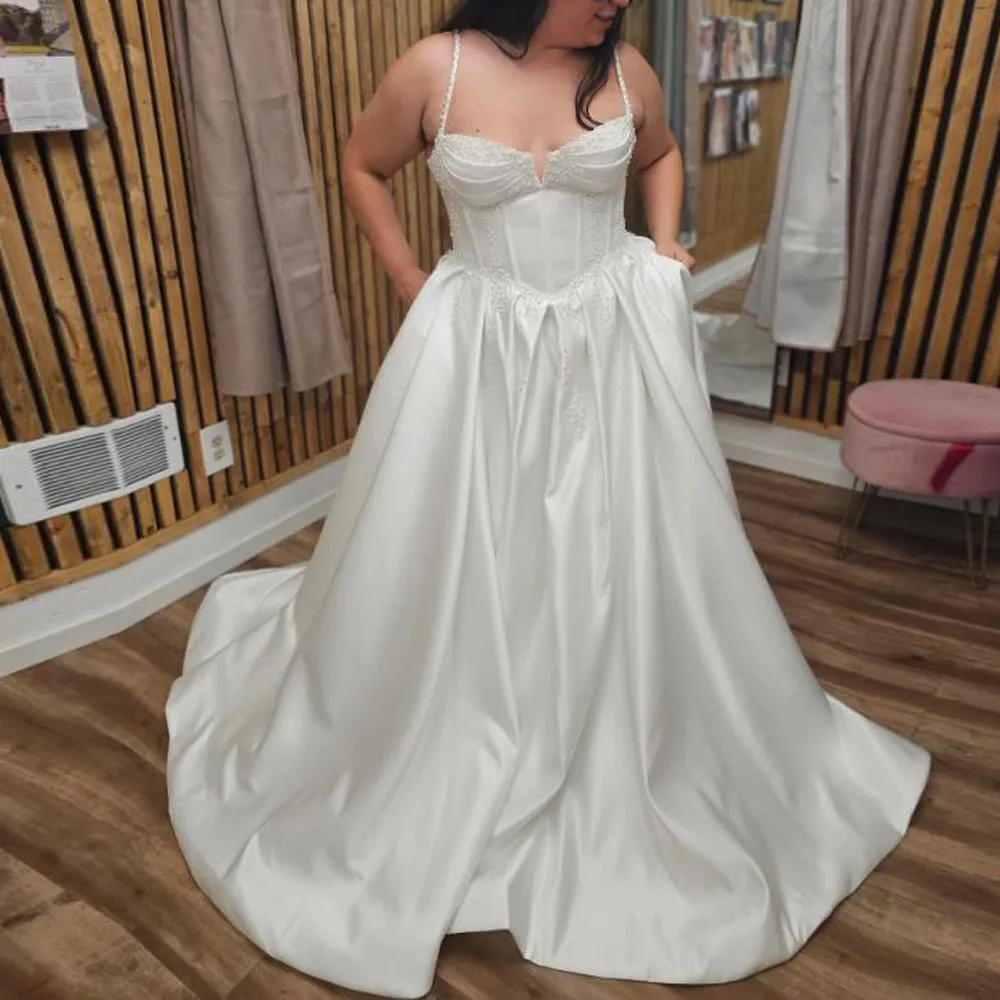 Customized Pearls Satin Wedding Dresses with Pockets Spaghetti Strap Corset Bride Gown Plus Size Vestidos De Novia
Customized Pearls Satin Wedding Dresses with Pockets Spaghetti Strap Corset Bride Gown Plus Size Vestidos De Novia