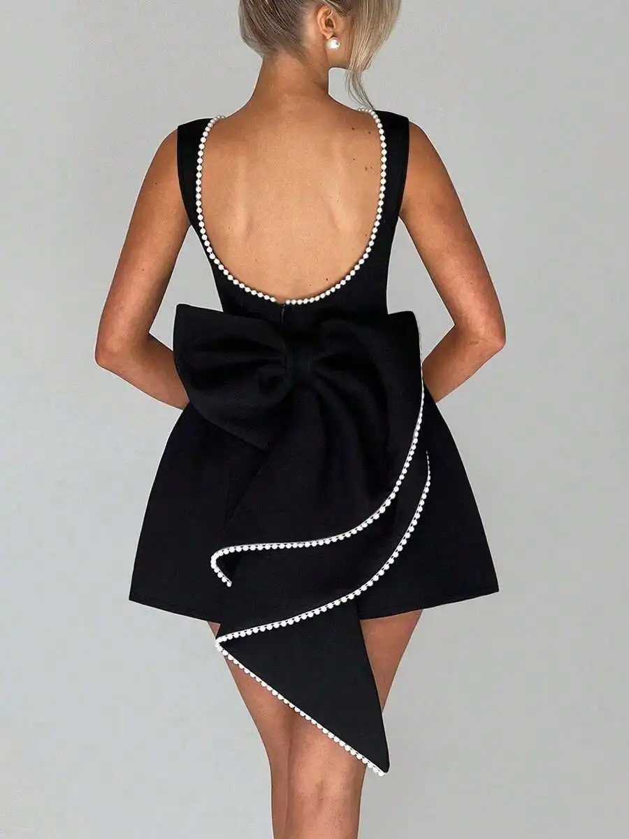 Черное мини-платье с бантом сзади и жемчужной отделкой, асимметричный подол
Черное мини-платье с бантом сзади и жемчужной отделкой, асимметричный подол