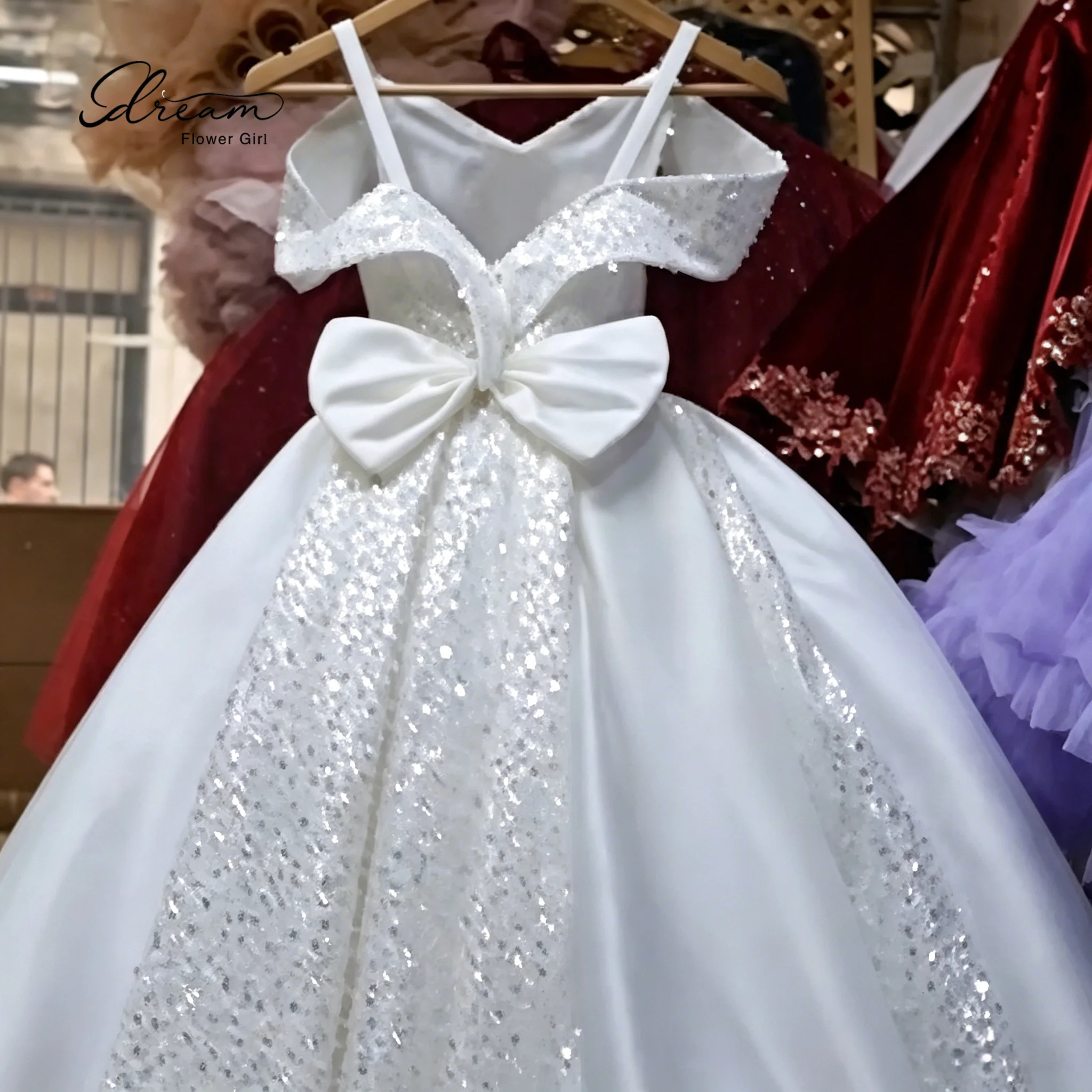 Girls' floor-length white chiffon sleeveless formal ball gown with a sequined bow at the waist and a full voluminous skirt
Girls' floor-length white chiffon sleeveless formal ball gown with a sequined bow at the waist and a full voluminous skirt