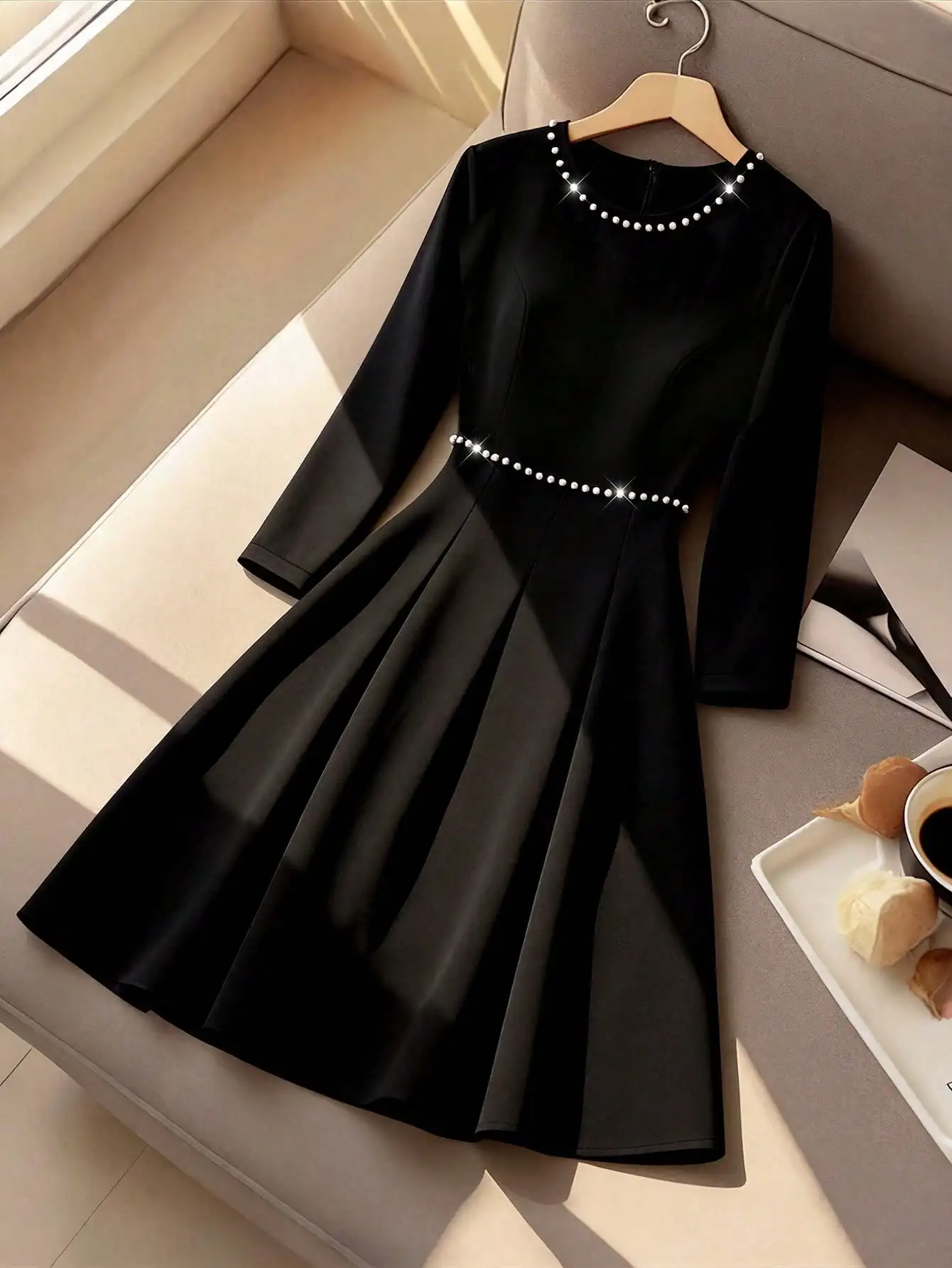 Черное платье А-силуэта с круглым вырезом, длинными рукавами и жемчужной отделкой на горловине и талии
Черное платье А-силуэта с круглым вырезом, длинными рукавами и жемчужной отделкой на горловине и талии