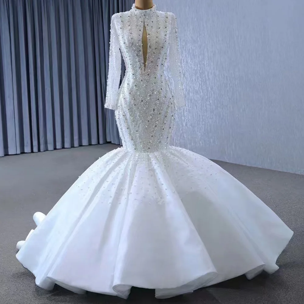 Элегантное свадебное платье-футляр 2026 года с длинными рукавами, кружевной шнуровкой на спине, вырезом «ключница», жемчугом и кристаллами, белое
Элегантное свадебное платье-футляр 2026 года с длинными рукавами, кружевной шнуровкой на спине, вырезом «ключница», жемчугом и кристаллами, белое