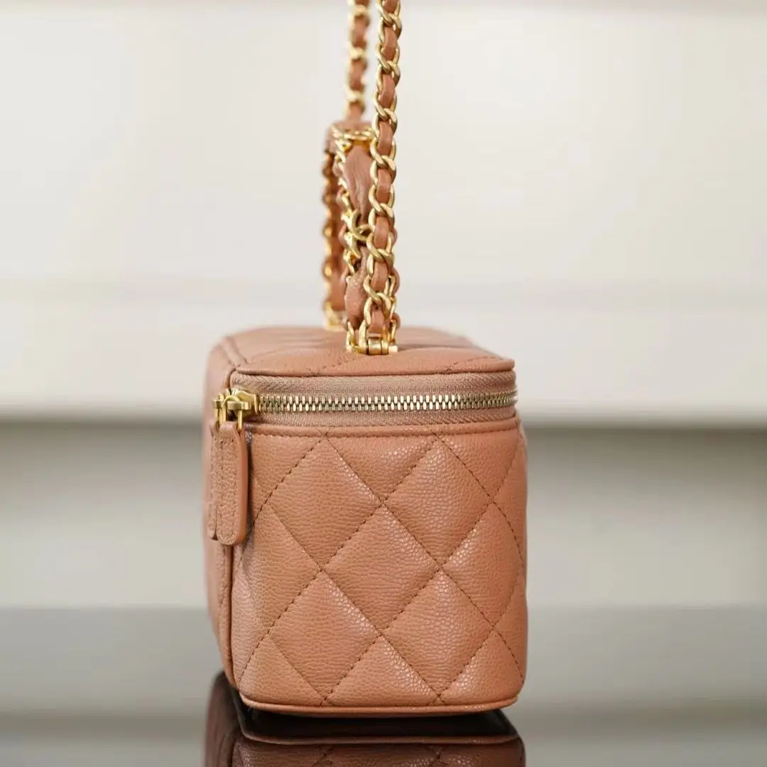 Caramel quilted leather vanity bag with gold-tone zipper, top handle, and detachable chain strap.
Caramel quilted leather vanity bag with gold-tone zipper, top handle, and detachable chain strap.
