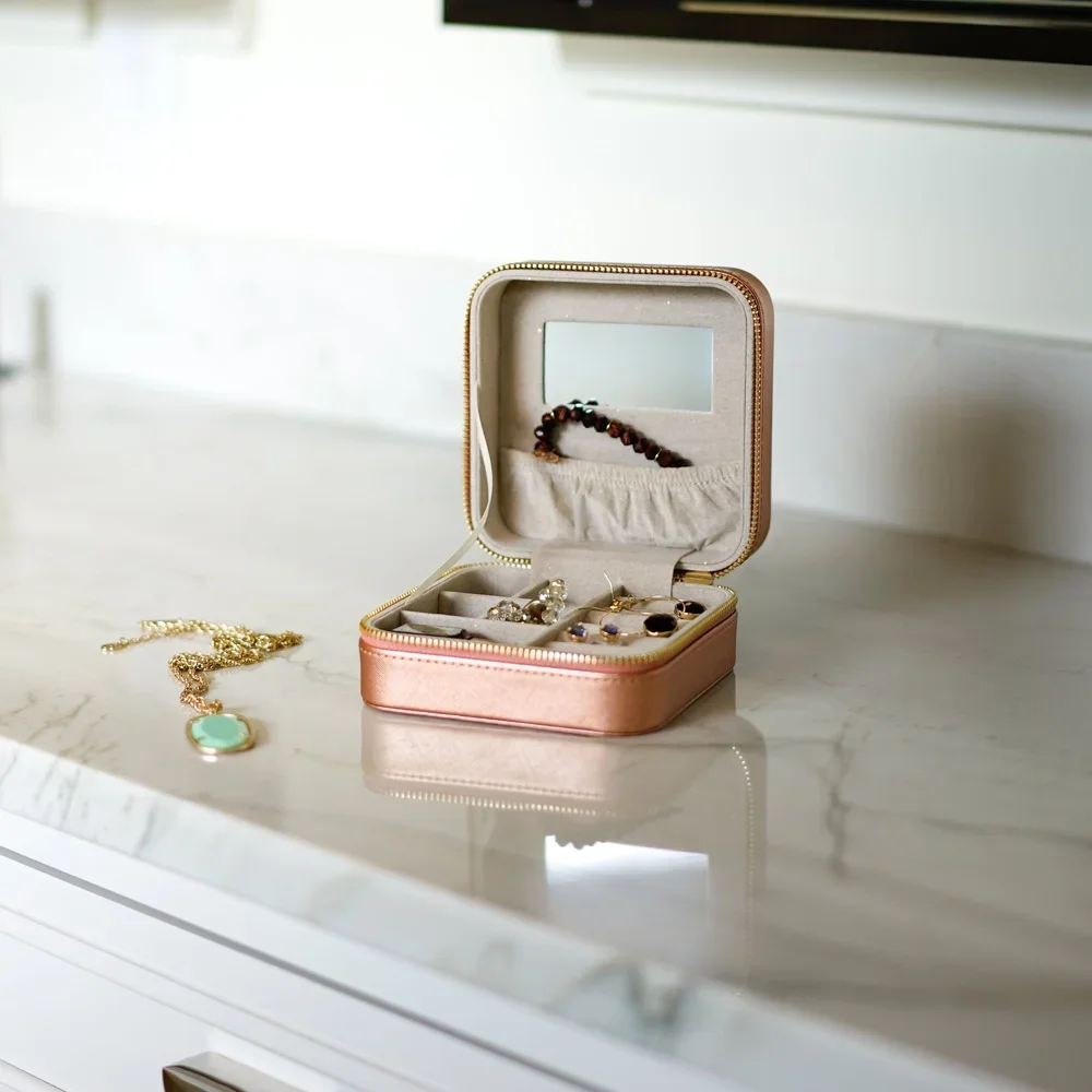 Женский дорожный футляр для украшений из искусственной кожи, компактный органайзер с зеркалом, держателями для колец, разделителями и мешочком для хранения
Женский дорожный футляр для украшений из искусственной кожи, компактный органайзер с зеркалом, держателями для колец, разделителями и мешочком для хранения