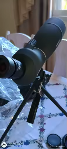Visão em close do telescópio Svbony montado em tripé sobre uma mesa
