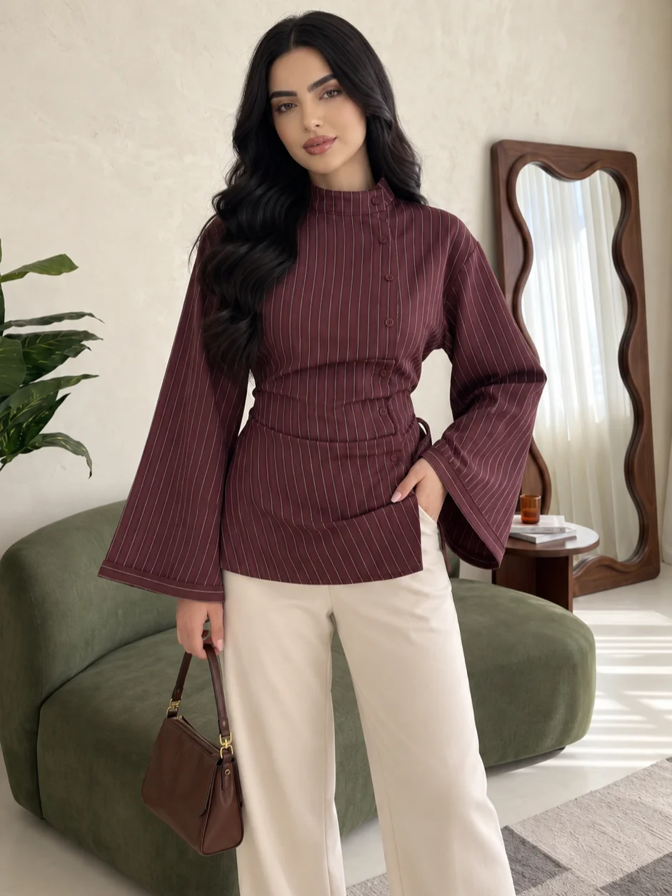 Elegant women’s vertical-striped shirt, featuring a stand collar with an asymmetrical button placket and long, flared sleeves.