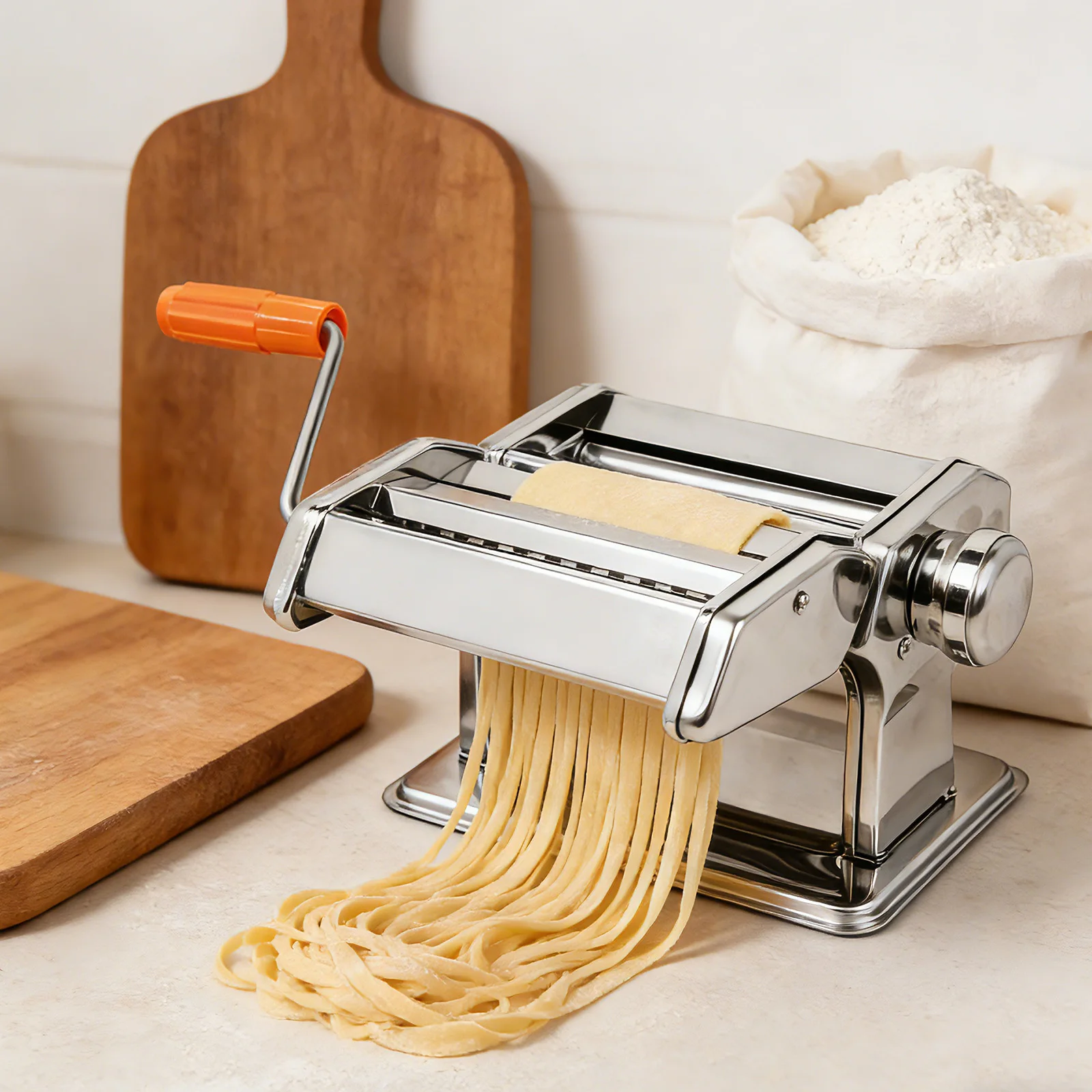 Pasta maker machine clamped to worktop rolling fresh pasta dough sheet