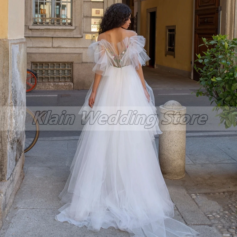 Abito da sposa Chic alto e basso con fiori abiti da sposa senza maniche in Tulle moda donna con strascico e volant su misura