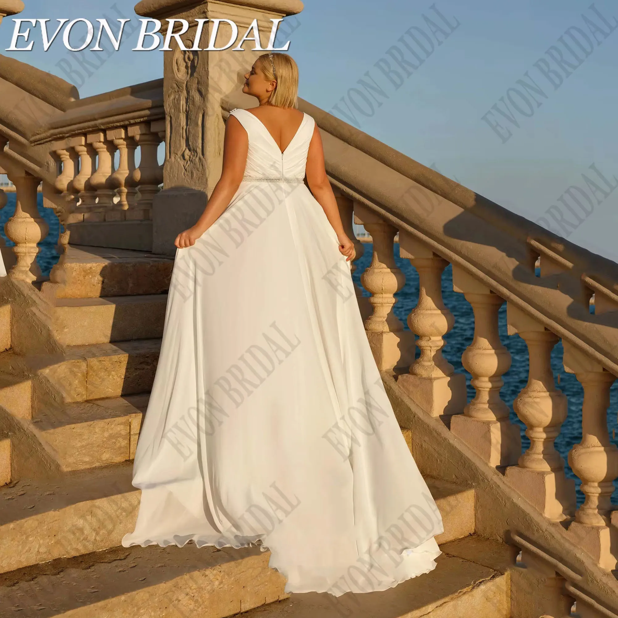 ชุดแต่งงานโอเวอร์ไซส์พร้อมผ้าคลุมไหล่ คอวี แขนกุด ชุดเจ้าสาวชายหาด ผ้าชีฟองทรงเอไลน์ ยี่ห้อ EVON BRIDAL รับตัดตามสั่ง