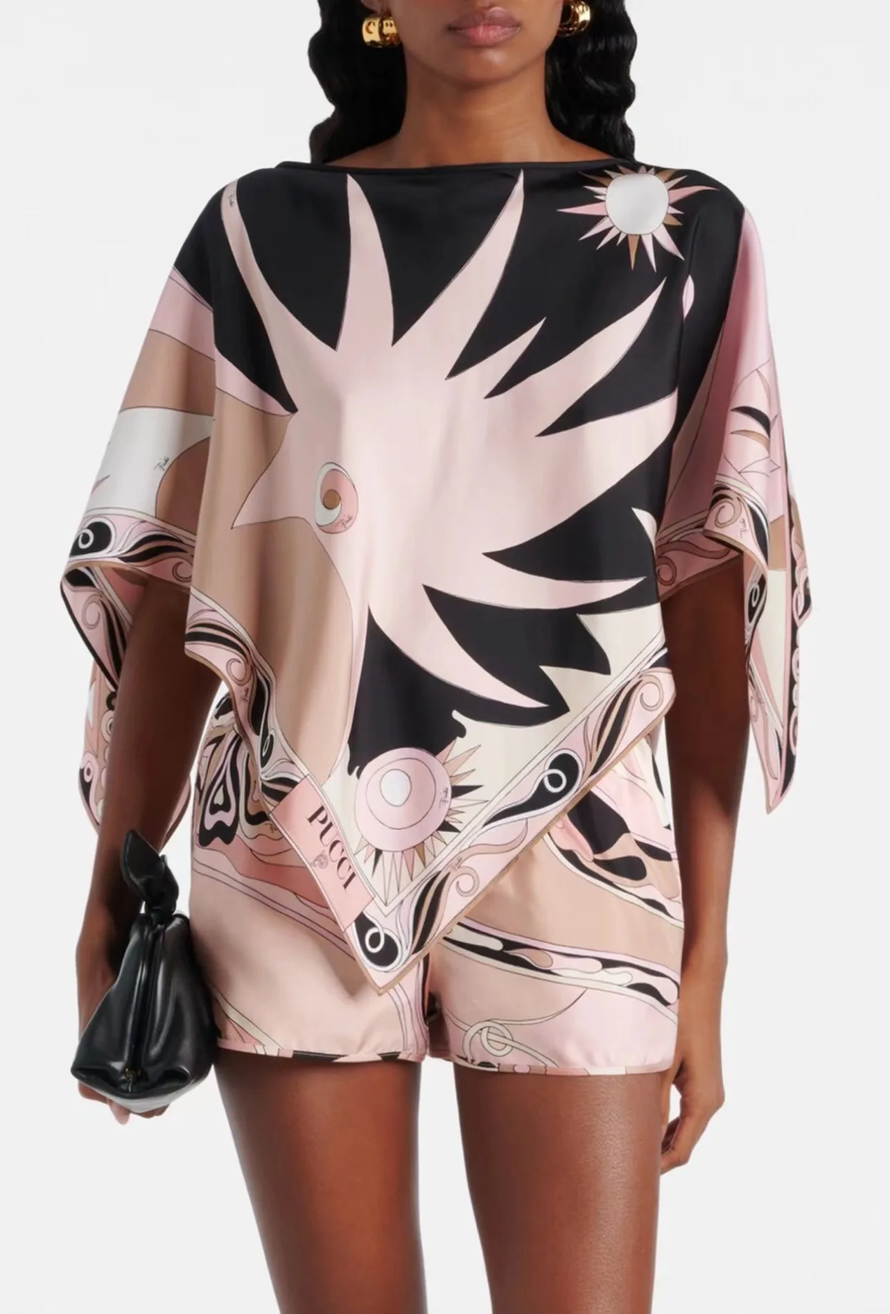 

Летний комплект из двух предметов Puc Silk: розово-черный топ с абстрактным солнечным принтом и рукавами «летучая мышь» и асимметричные шорты. Наряд для отпуска.