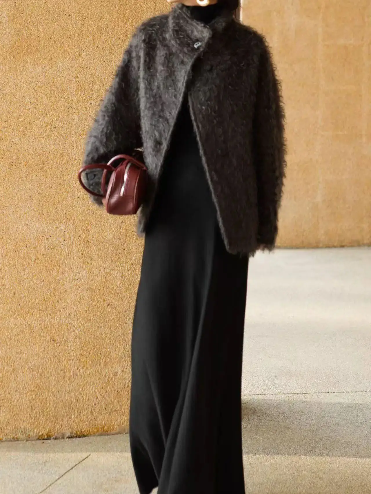 Minimalistyczny zimowy płaszcz damski ze stójką, o średniej długości, wykonany z mieszanki moheru i wełny.