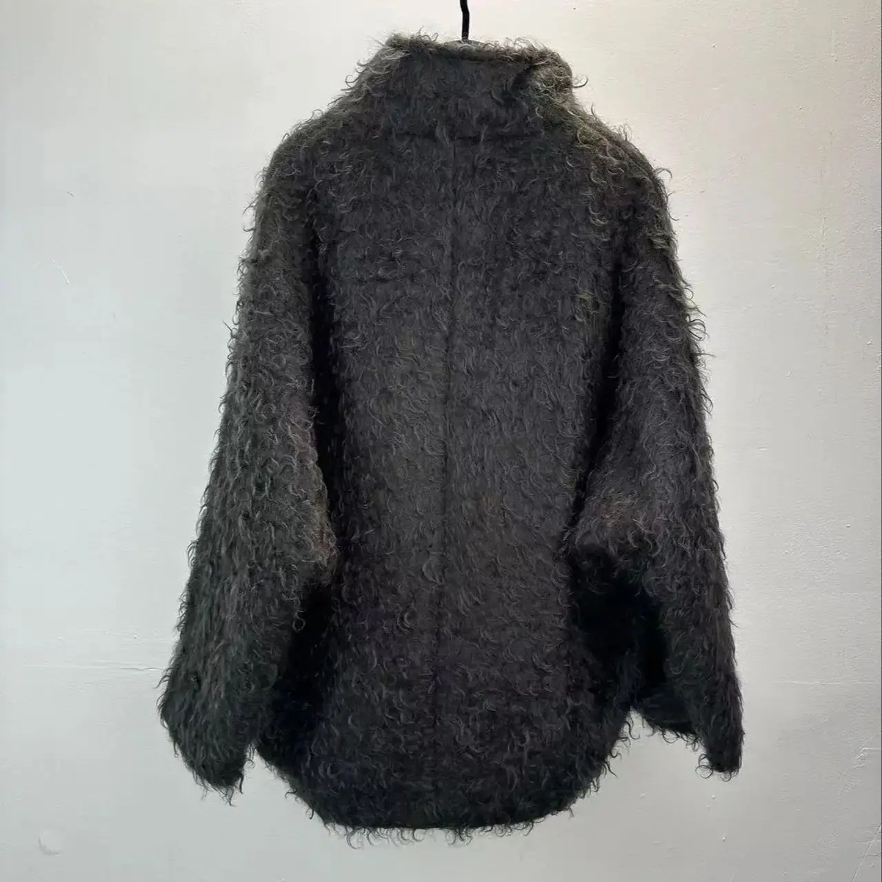 Minimalistyczny zimowy płaszcz damski ze stójką, o średniej długości, wykonany z mieszanki moheru i wełny.