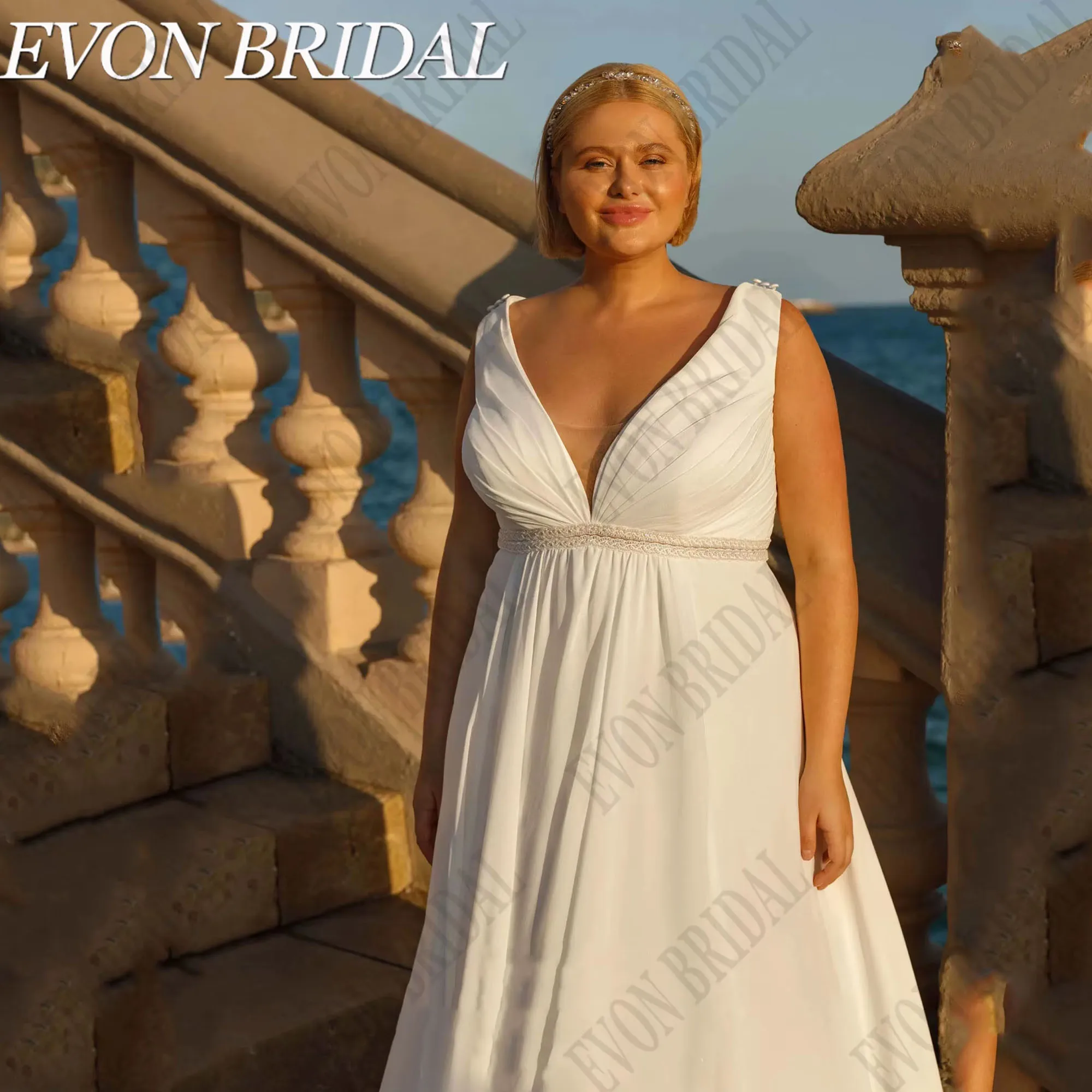 ชุดแต่งงานโอเวอร์ไซส์พร้อมผ้าคลุมไหล่ คอวี แขนกุด ชุดเจ้าสาวชายหาด ผ้าชีฟองทรงเอไลน์ ยี่ห้อ EVON BRIDAL รับตัดตามสั่ง