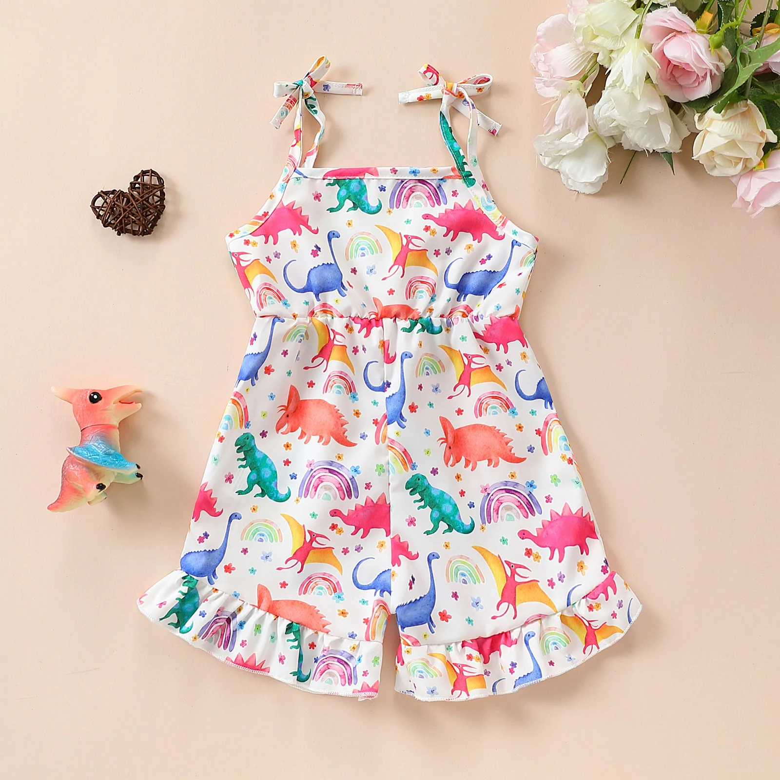 

Детский комбинезон с динозавром и радужным принтом: бретельки + рюшами по краю — красочный для летних игр.