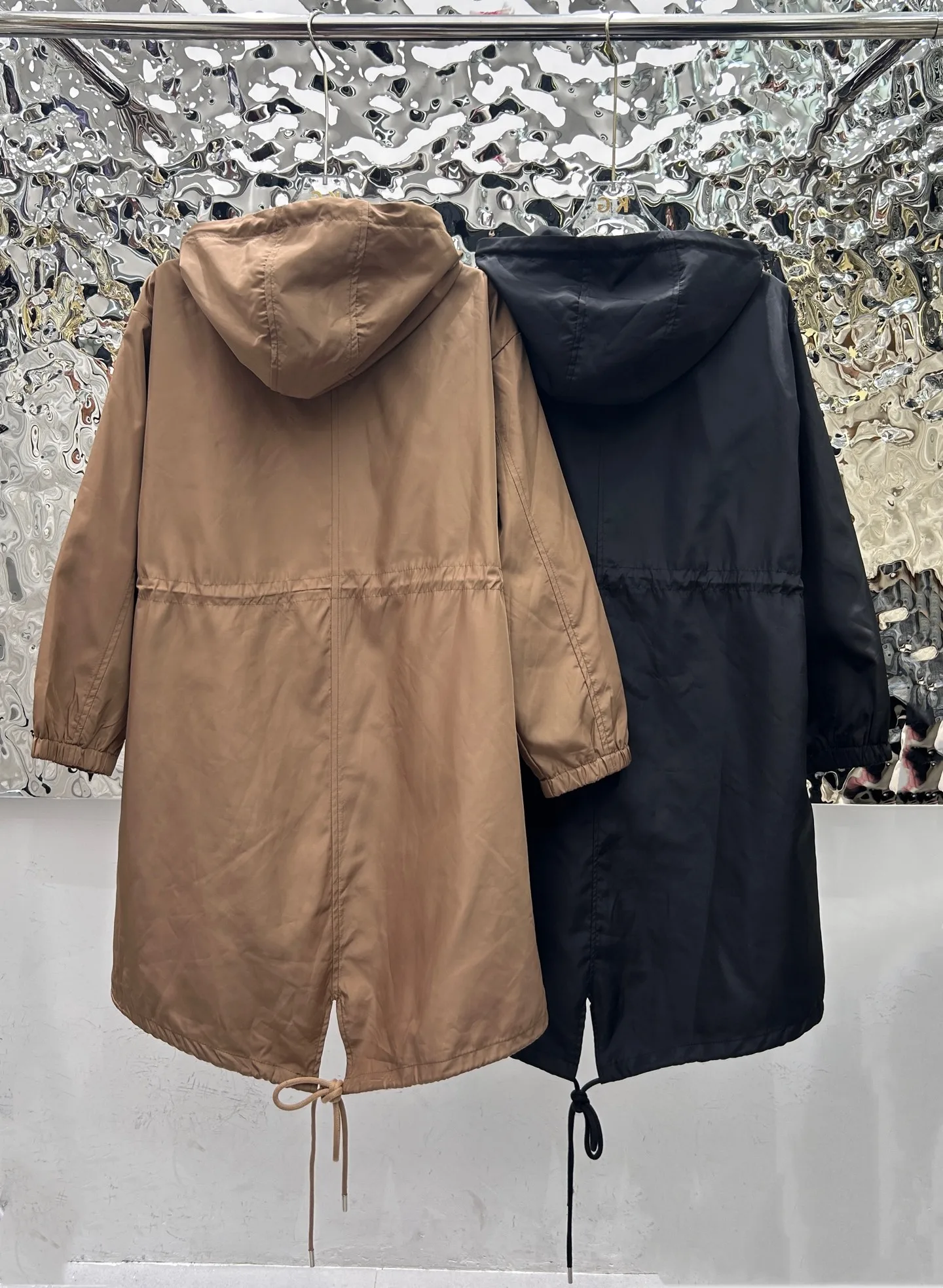 

2025 Новое длинное пальто с капюшоном из гладкой ткани и шнурком на талии и подол