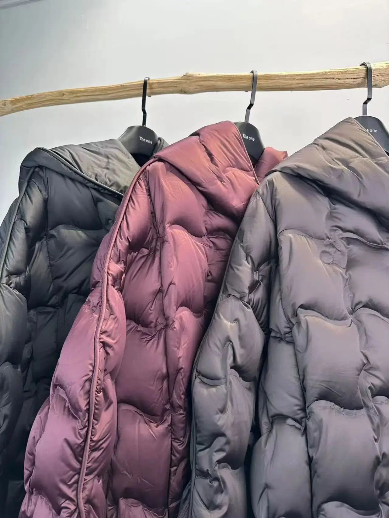 Elegante, minimal hochwertige Daunenjacke mit schrägen Knöpfen und Kapuze