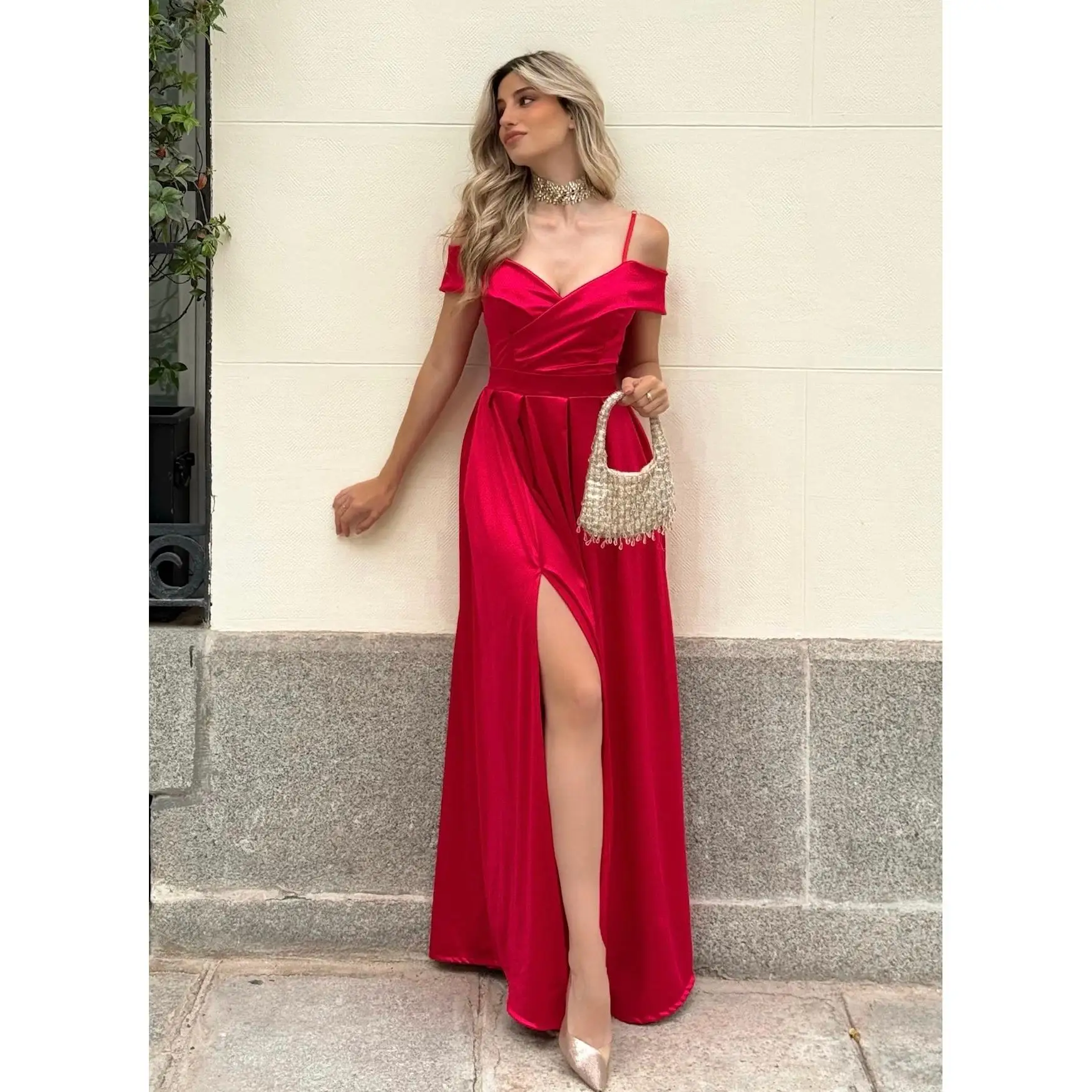 Vestido largo tejido de raso, escote corazón de hombros caídos y tirantes finos regulables. Cremallera trasera invisible con abertura delantera mostrando la pierna, relleno en el pecho.