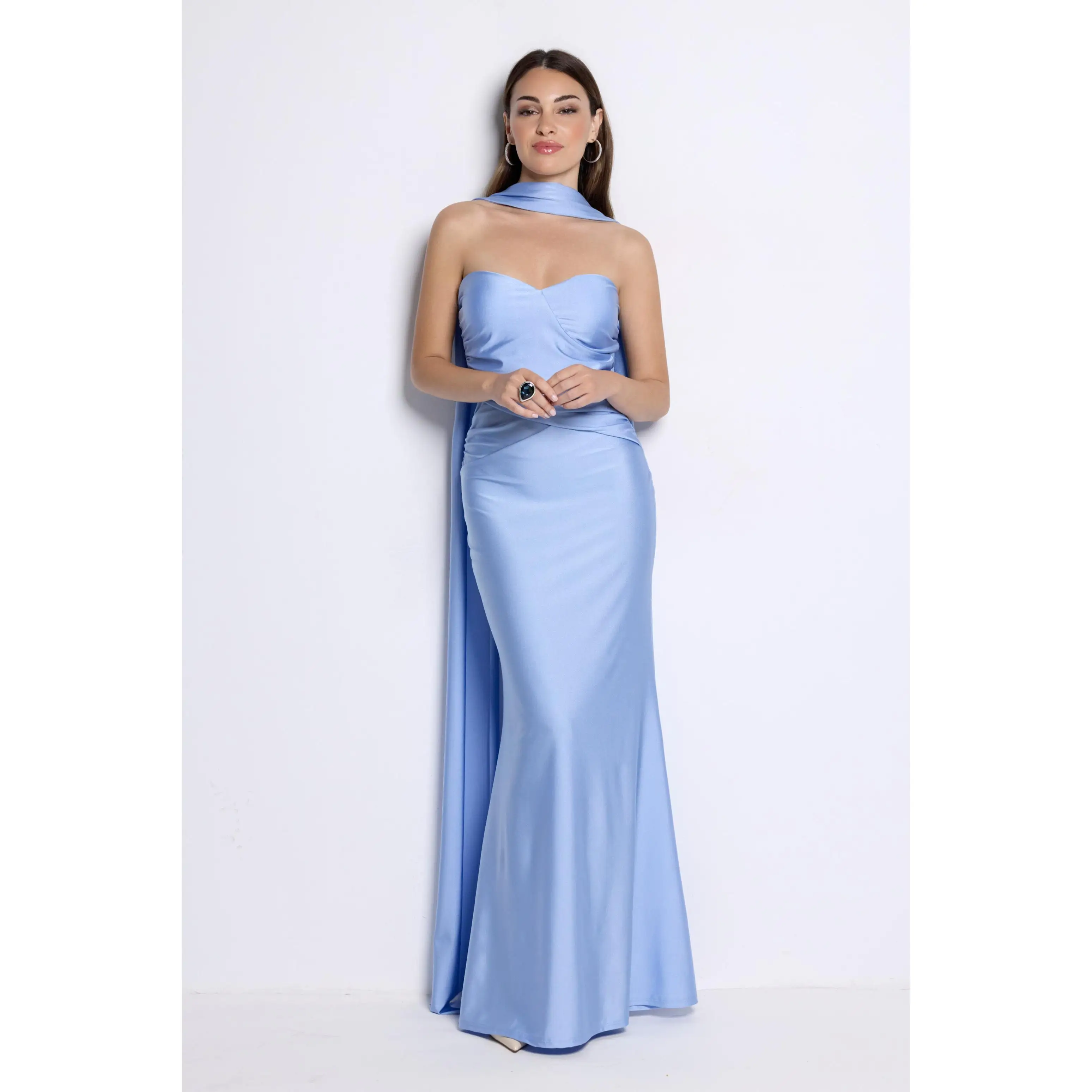 Vestido largo con escote palabra de honor y detalles fluidos que aportan un toque romántico y sofisticado. Su corte ajustado y drapeado en la cintura realzan la silueta, incluye echarpe. El tejido