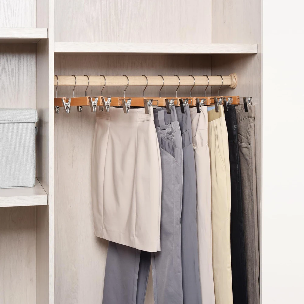 Wooden hanger with adjustable clips in white and natural color, featuring a 360° swivel hook, perfect for organizing pants and skirts in your wardrobe. Ideal for space-saving and easy access to clothes. #5