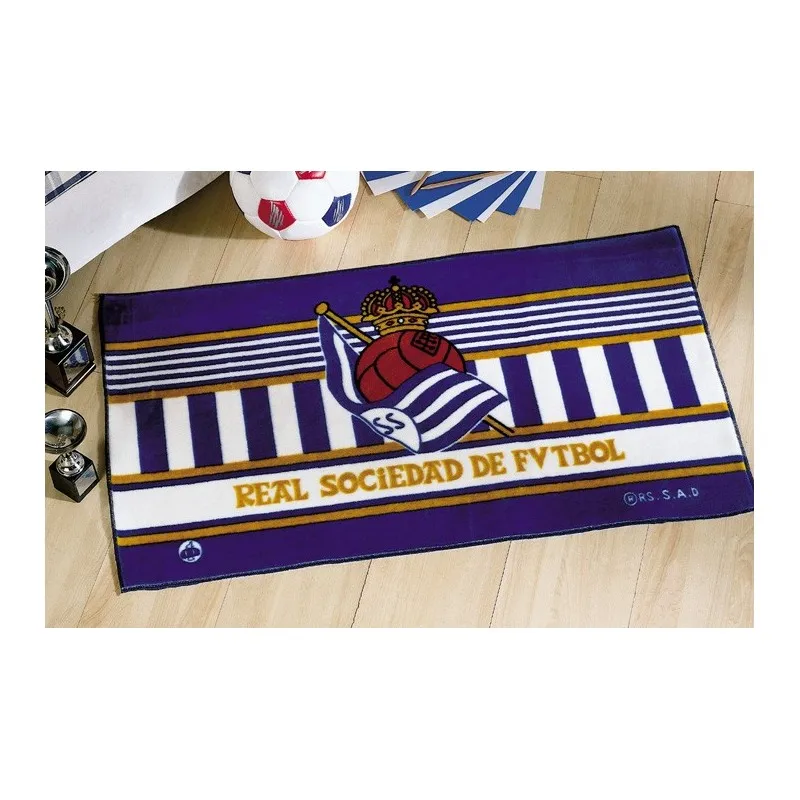 Carpet carpet Real soccer society. Ideal to place at the foot of the bed. Measures: 55x110 cm. Composition: 85% acrylic 15% polyester colors may differ slightly from the image shown made in Spain official license