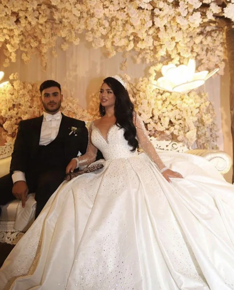 

2025 Luxury Arabic Dubai Wedding Dress V Neck Beaded Crystal Long Sleeve Satin Floor Length Puffy Bridal Gown Vestidos De Noiva
