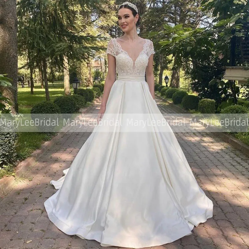 

Plunging V-neck Princess Wedding Dress With Illusion Lace Bodice Satin Skirt Cap Sleeves Bridal Gowns Bow Tie Belt Bride Dresses