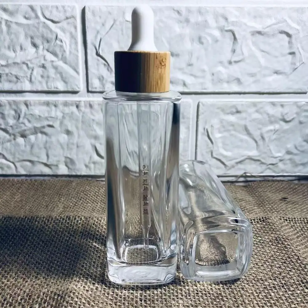 

Wholesale Custome Logo Square Clear Glass Dropper Bottles With Bamboo Lid Lotion Perfume Bottle Skin Care Packaging