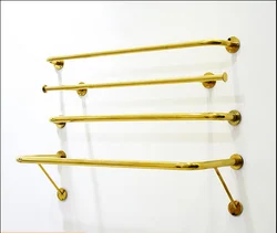 On the wall, hang the clothes shelf of women's clothing store, wedding dress, wall shelf, golden clothes hanger.