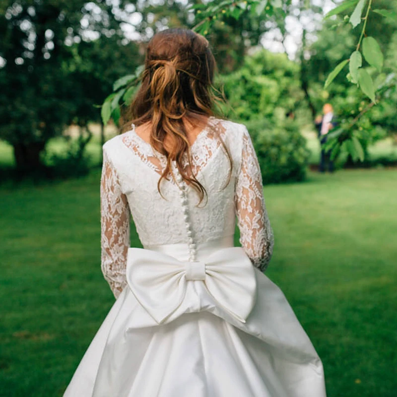 Grandi abiti da sposa con scollo tondo in raso Bowknot su misura Plus Size rustico elegante maniche lunghe in pizzo bottoni abito da festa di nozze