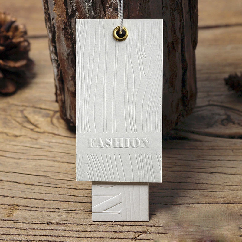 

Customized 4.5*8.5cm Off-White Paper Card Embossed Seal Clothing Hang Tag in 700G Thickness