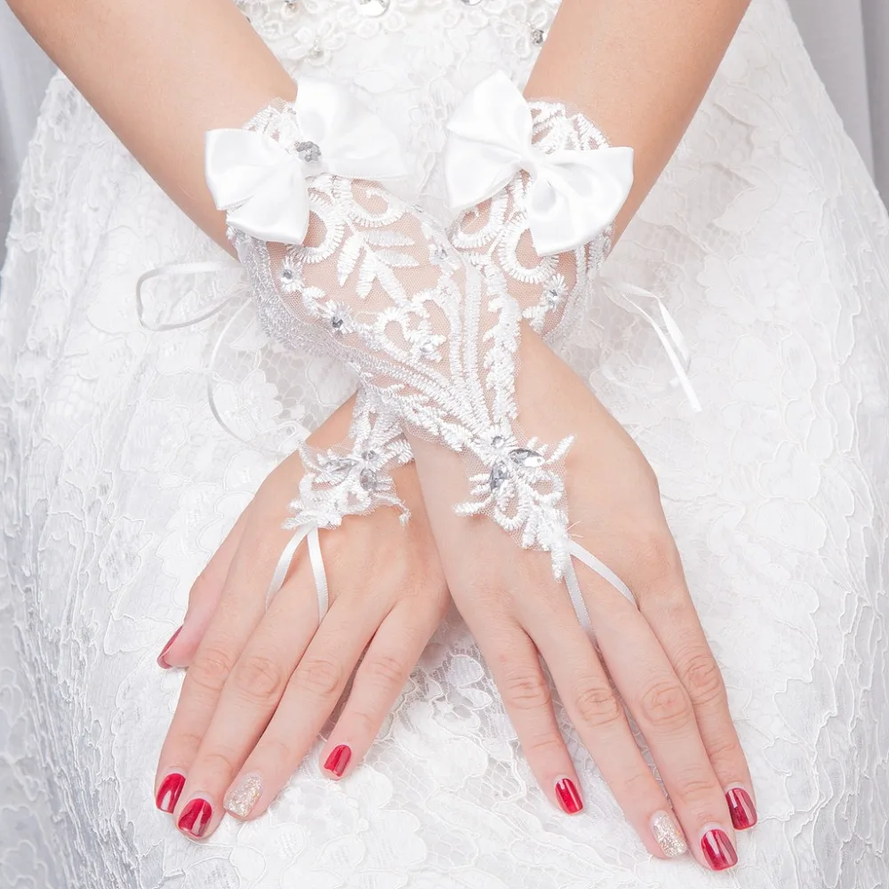 JaneVini Ngắn Cổ Tay Găng Tay Dài Cưới cho Cô Dâu Đính Cườm Nơ Ren Găng Tay Cô Dâu Ngón Phụ Kiện Hochzeit Handschuh 2018