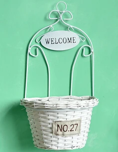 Wicker manual. On the wall., wrought iron wall hanging. Decorative flower basket.