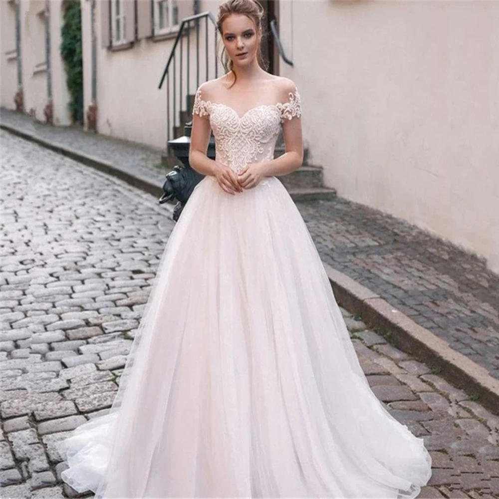 Eleganckie suknie ślubne O Neck krótki bez pleców rękawy koronkowe aplikacje tiul linia sąd pociąg plażowa suknia ślubna Robe De Mariée