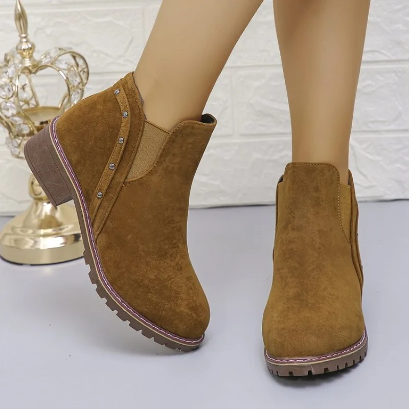 Botines sin cordones para mujer con punta redonda, tacón bajo, textura efecto ante, detalle de tachuelas, panel elástico y suela texturizada.