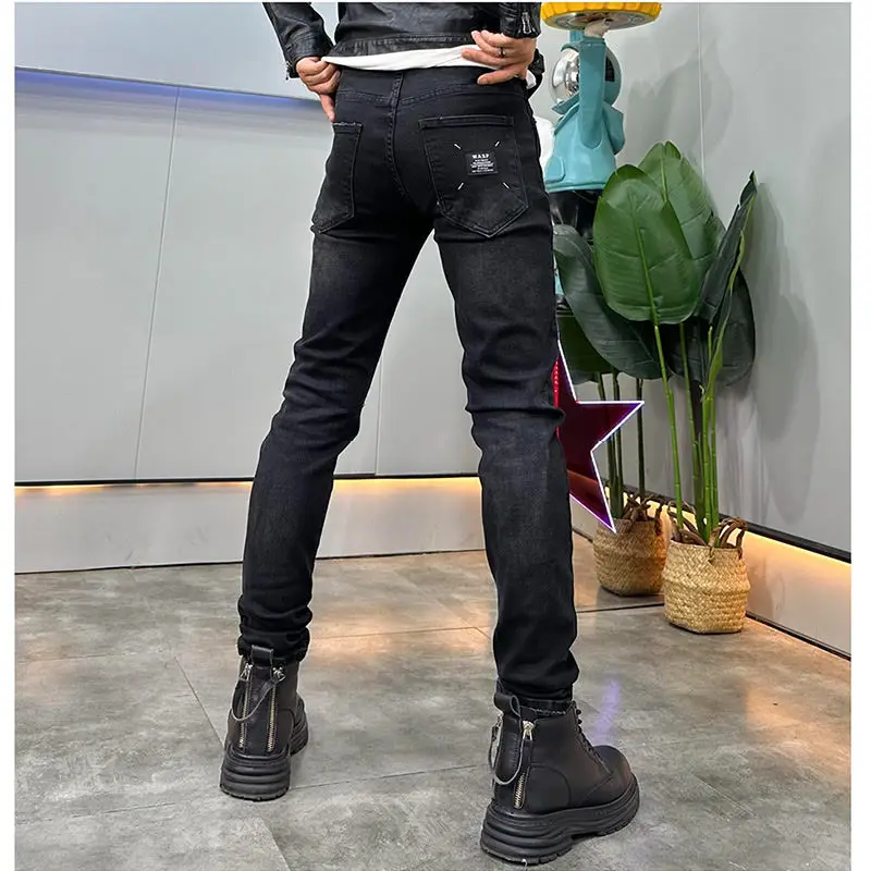 カウボーイデニムブラックフェイクリップドジーンズメンズトレンドブランド秋冬2025新作ファッショナブルな伸縮性スリムスキニージーンズパンツ男性用