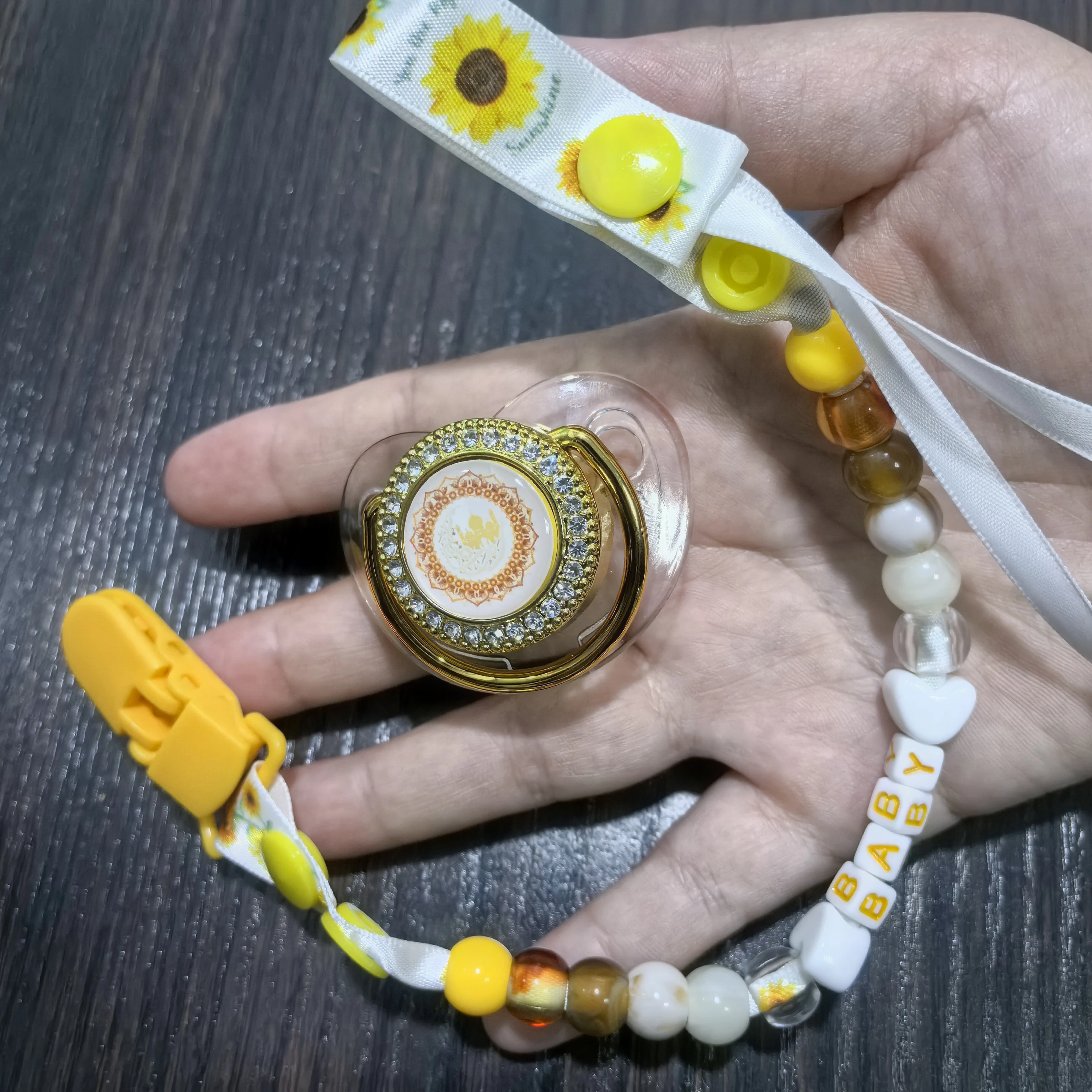 

Элитный исламский набор для кормления - тематика Ид, золотой щит с стразами, зажим для ленты с подсолнухом, желтые и коричневые бусины