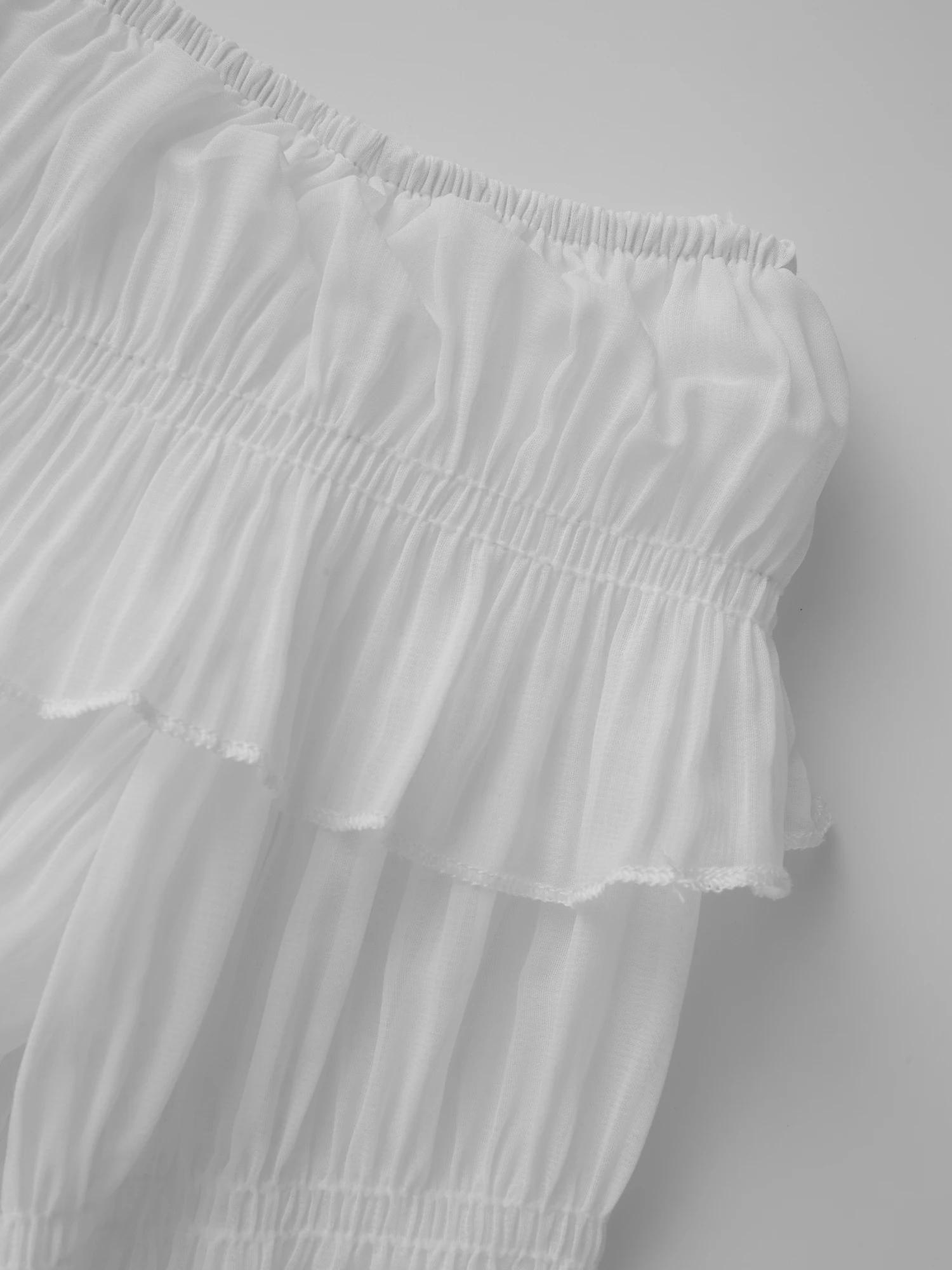 بلوزة أنيقة مزينة بالدانتيل مكشوفة الكتف بأكمام جرس وتفاصيل مطرزة بالزهور لفصلي الربيع والصيف