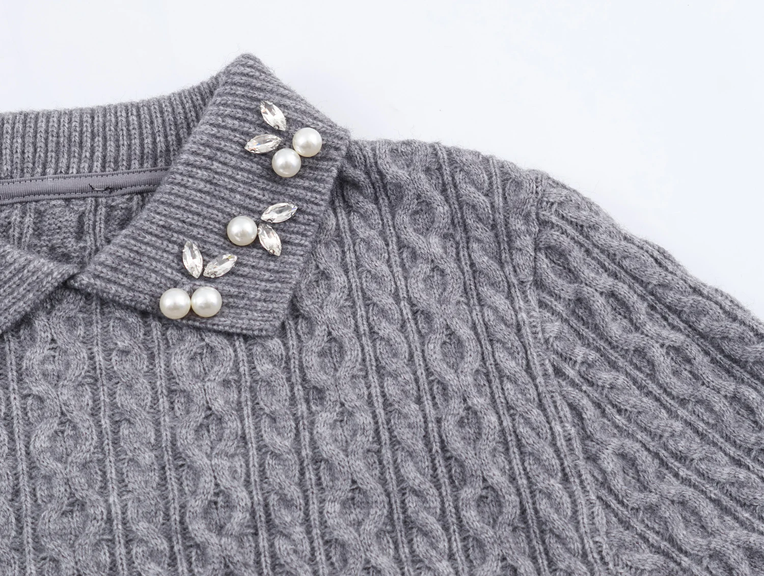 Europejski i amerykański styl, nowa kolekcja jesień-zima 2025, modny, elegancki sweter z dzianiny o sześcio- lub ośmiowarstwowej strukturze, ozdobiony biżuteryjnie dekoltem.