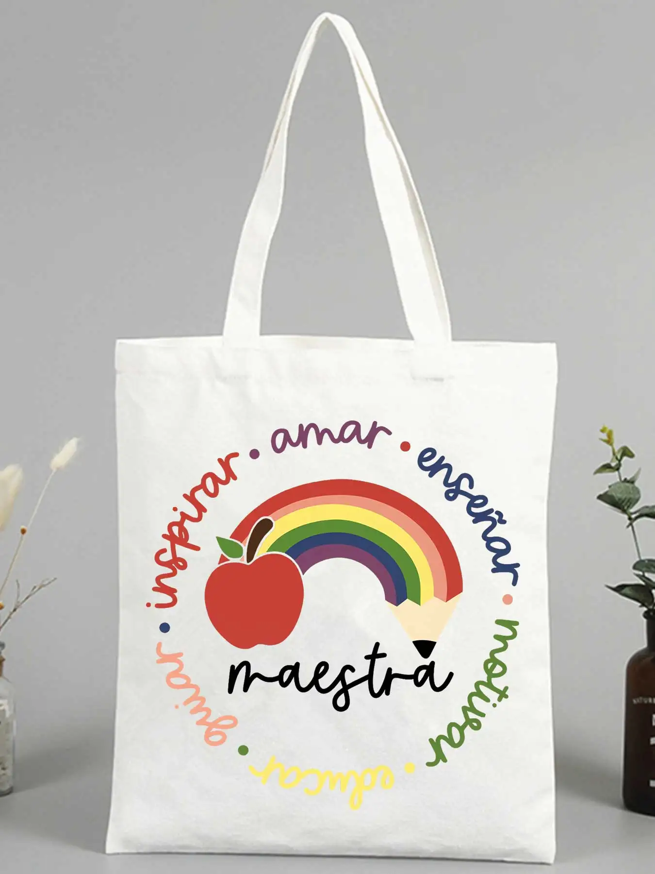 Teacher's canvas tote bag with rainbow, apple and pencil graphic, perfect for school supplies and daily teaching use