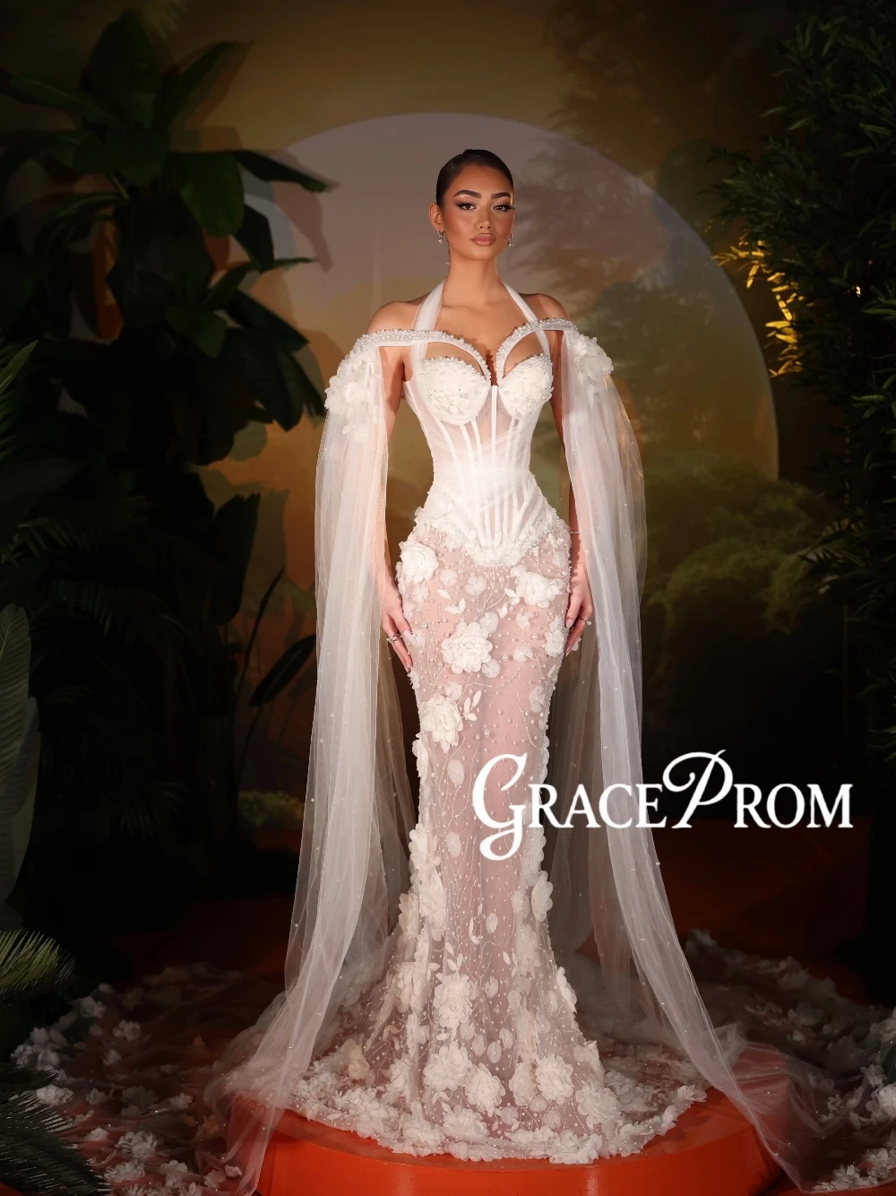 Suknia ślubna typu syrena z dekoltem halter, przezroczystej siateczki, z kwiatami 3D, zdobiona koralikami, z tiulową peleryną, iluzoryczna, romantyczna, z perłami, szyta na miarę.