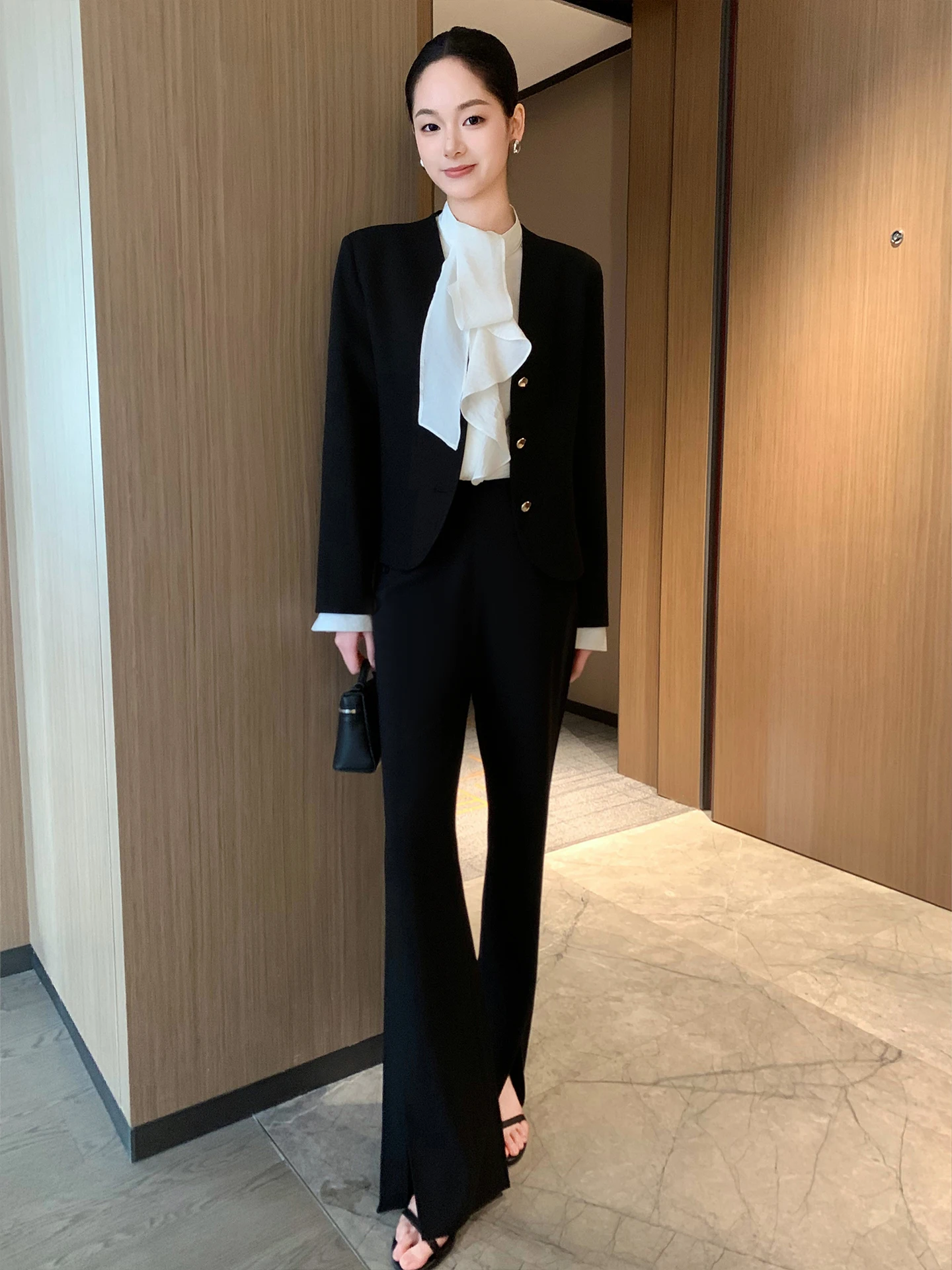 Dopasowany krój, dekolt w serek, długi rękaw, damski żakiet, czarny, z podkreśloną talią, warstwowa odzież wierzchnia, wiosna 2026, modny, uniwersalny.