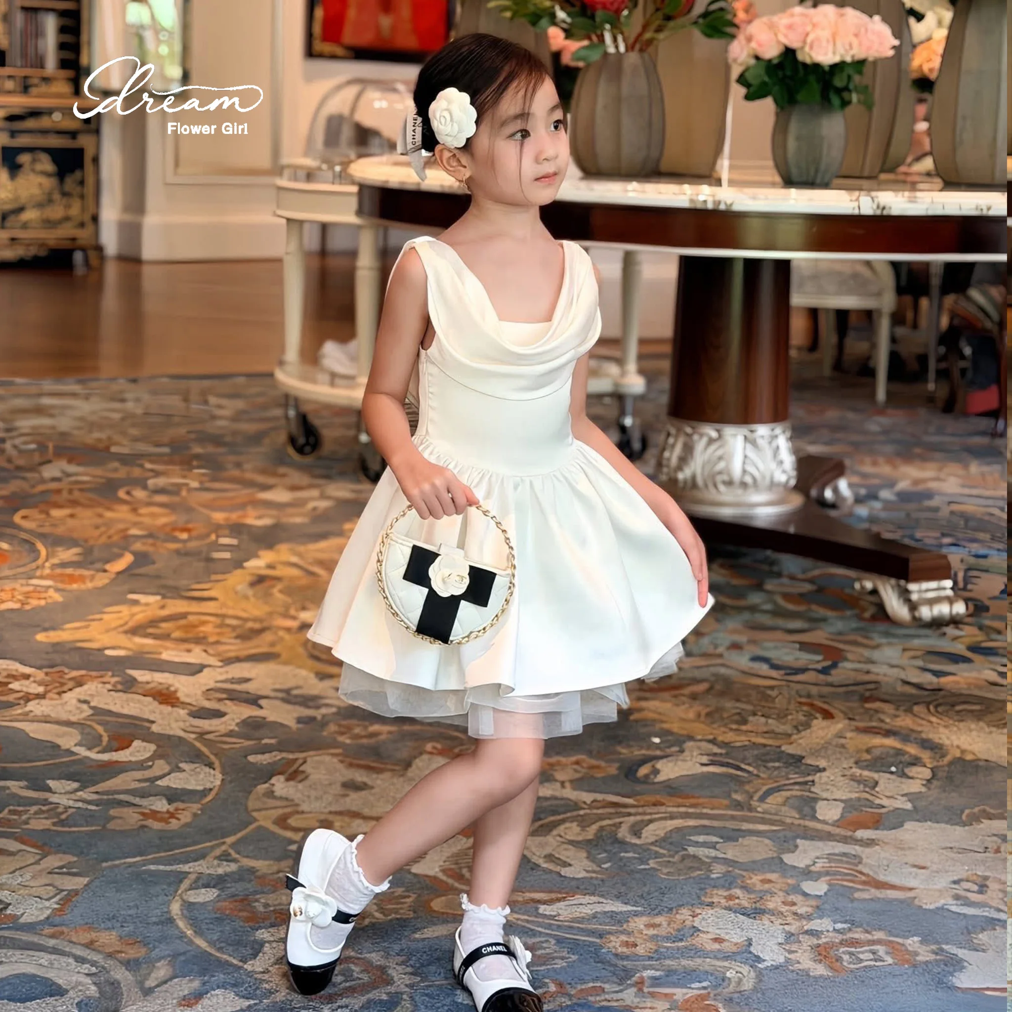 Ivory sleeveless knee-length formal party dress for girls featuring a draped voluminous skirt