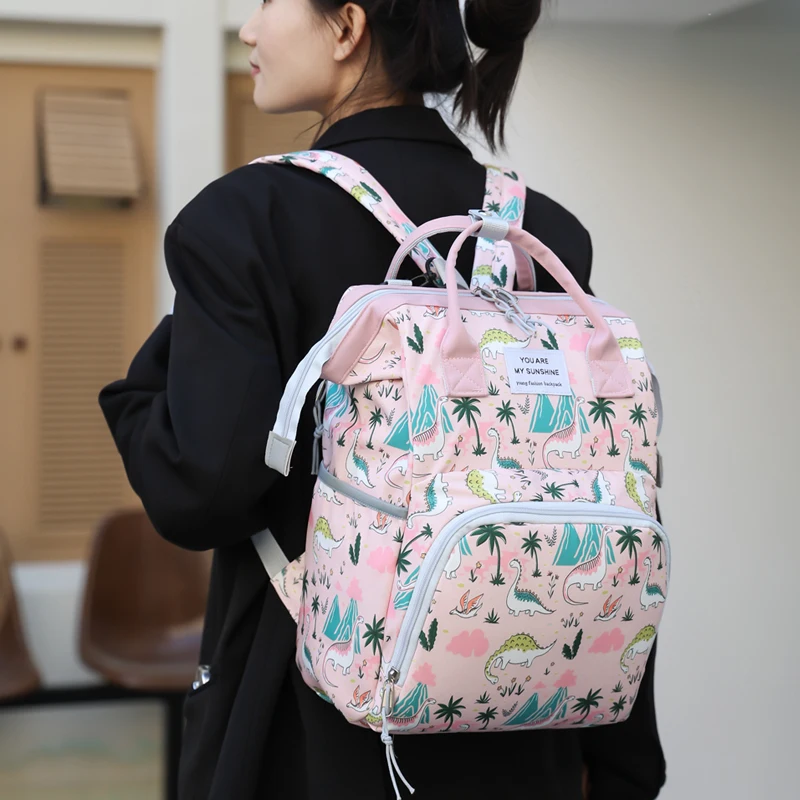 A lady hand-held mini mummy bag, cute dinosaur print backpack, suitable for daily use with a baby