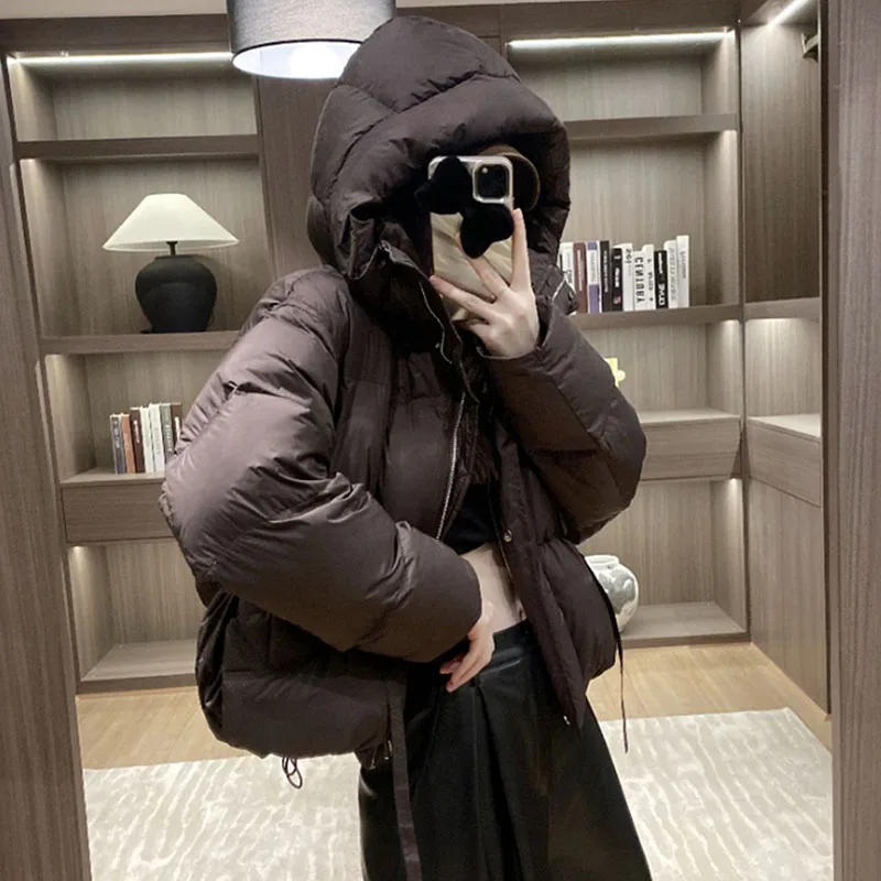 เสื้อแจ็คเก็ตขนเป็ดสีขาวสำหรับผู้หญิง เสื้อโค้ทกันหนาวแบบมีฮู้ด รุ่นใหม่ปี 2025 เสื้อแจ็คเก็ตขนเป็ดผู้หญิงทรงหลวม หนา อุ่น สไตล์แฟชั่นเกาหลี