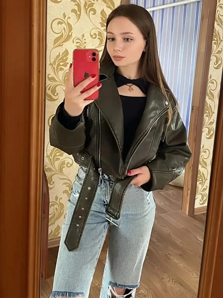 سترة قصيرة للسيدات كبيرة الحجم موديل 2025 من الجلد الصناعي الصناعي مع حزام ملابس الشارع الشهير معطف نسائي بسحاب ريترو موتو لراكبي الدراجات النارية ملابس خارجية