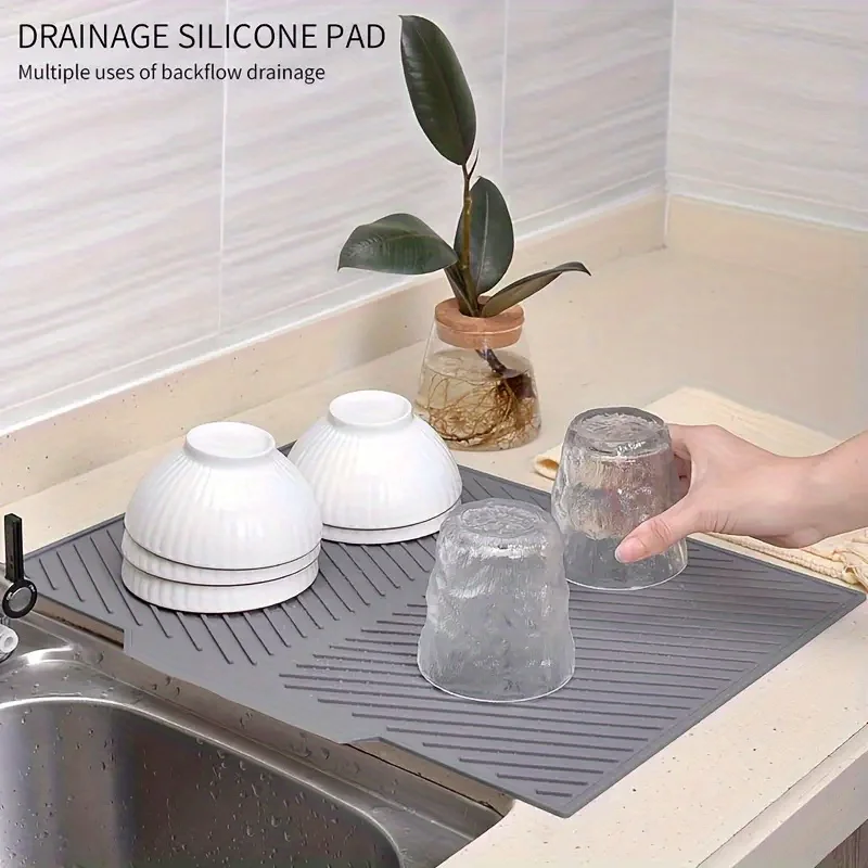 Diese Silikon-Küchenmatte kann als Spritzschutz und Abtropfmatte verwendet werden, mit rutschfestem Design und Abflusslöchern.