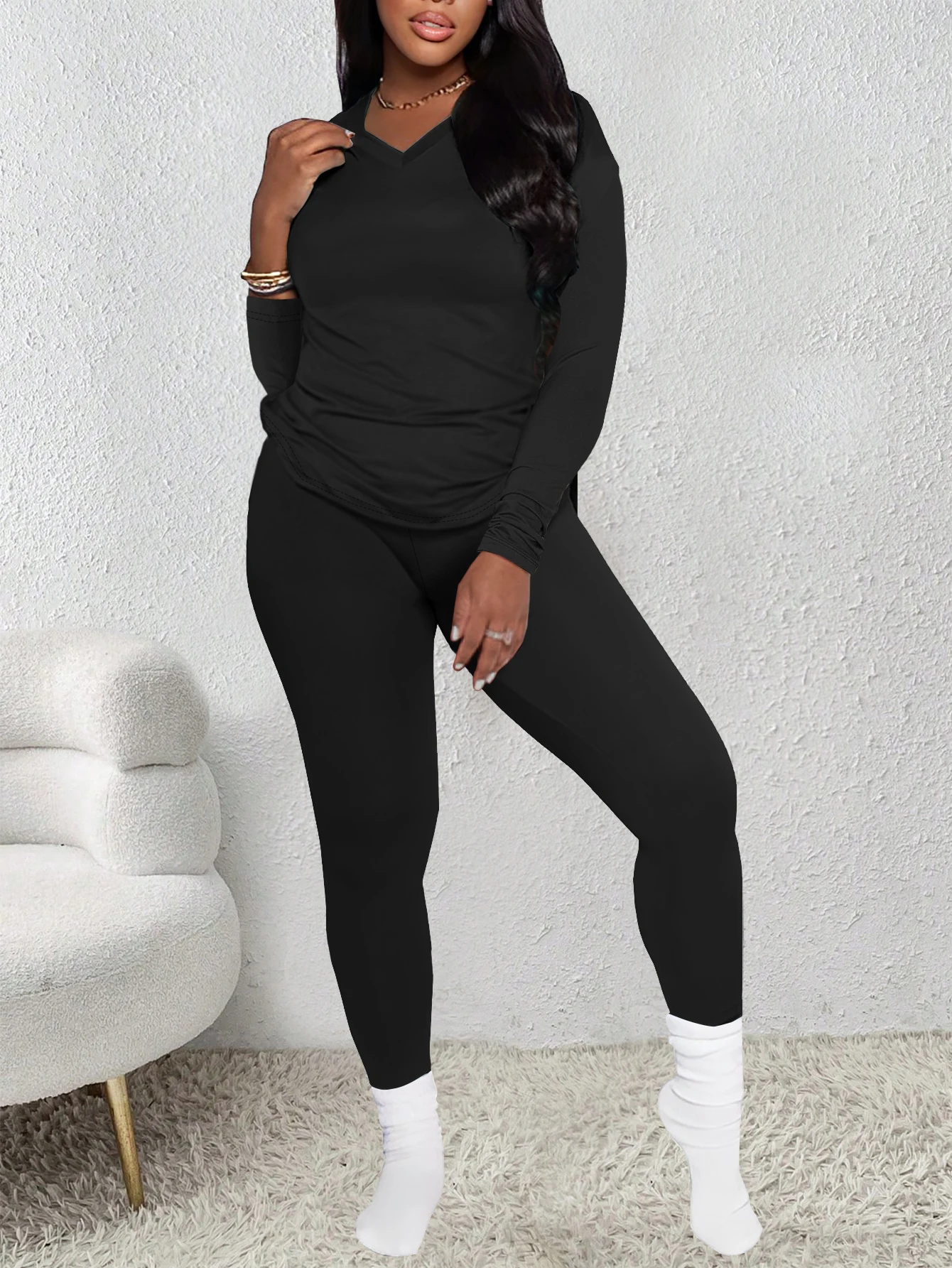 

Черный топ с V-образным вырезом и длинными рукавами в сочетании с модными брюками узкого кроя