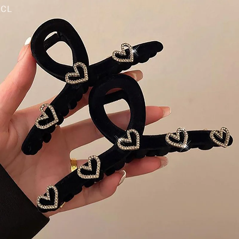 말꼬리 팬 스타일을 위한 라인스톤 디테일이 있는 절묘한 블랙 플로킹 헤어 클립.