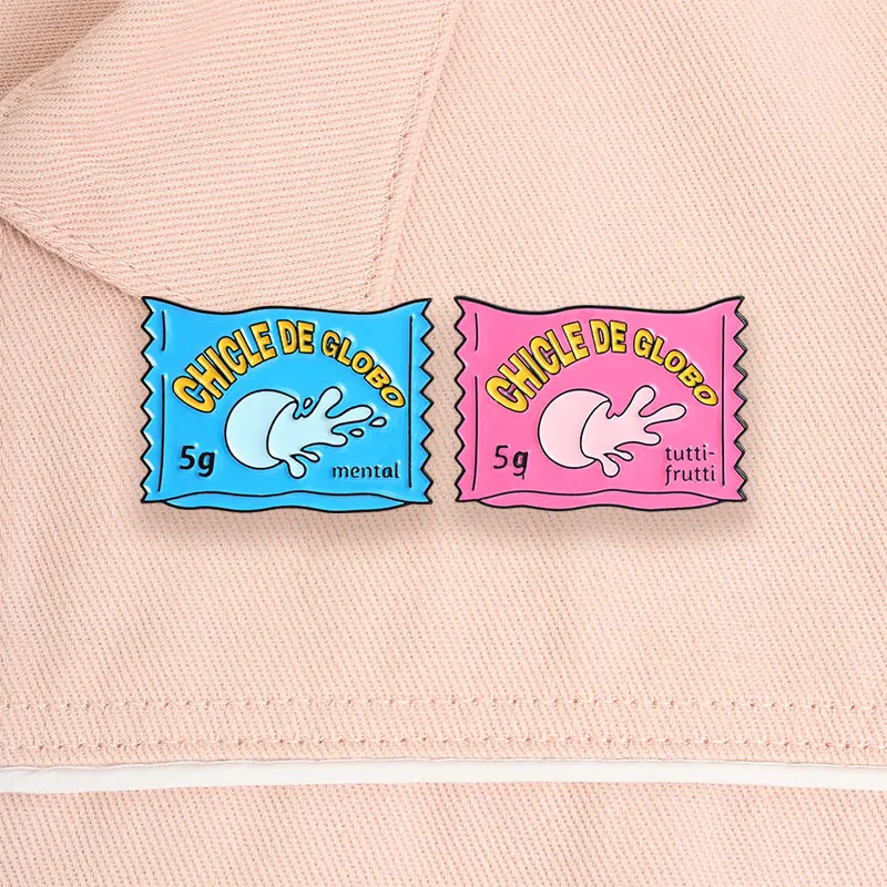 Un broche metálico esmaltado vintage con diseño de paquete de chicle de globo, adecuado para atornillar a la ropa.